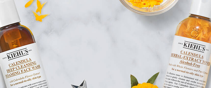 Kiehl’s Calendula Collection featuring Deep Cleansing Foaming Face Wash, Herbal-Extract Toner, and Serum-Infused Water Cream on floral background